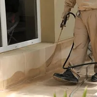 General pest control technician spraying exterior perimeter around a home in San Jose, CA