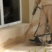 General pest control technician spraying exterior perimeter around a home in San Jose, CA